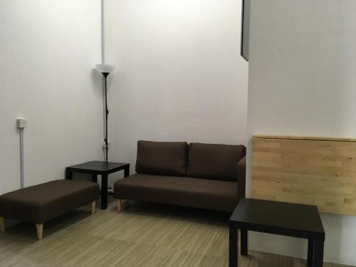 a living room with a couch and two tables at Homey Hostel, Ipoh Town in Ipoh