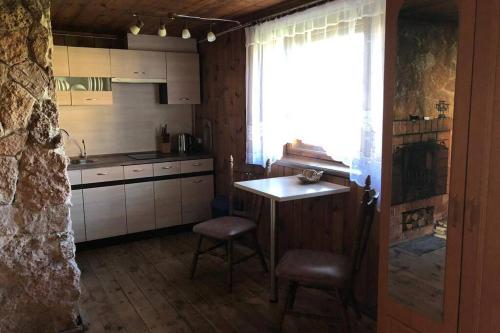 a kitchen with a table and chairs and a window at Atpūta pie jūras in Bigauņciems