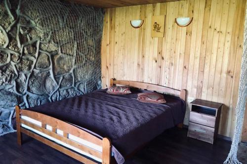 a bedroom with a bed in a stone wall at Atpūta pie jūras in Bigauņciems