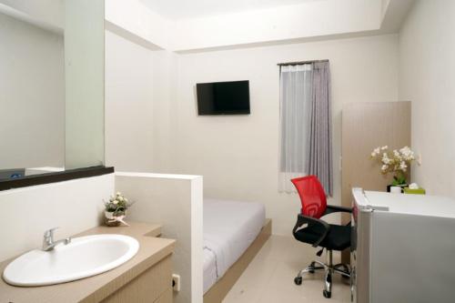 a bathroom with a sink and a bedroom with a bed at D'Paragon Manduro in Solo