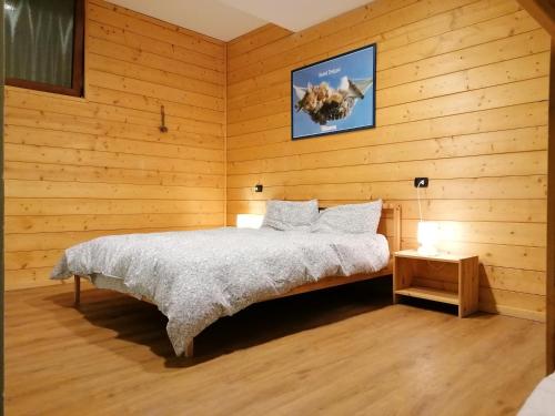 1 dormitorio con 1 cama en una pared de madera en Villa VaLuRi vista magnifica sul Lago di Como Appartamento piano terra, en Vercana