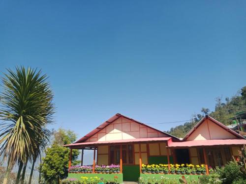 una casa con una palmera delante en Vamoose Niru, en Pedong