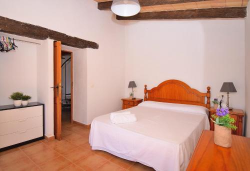 sypialnia z dużym łóżkiem z drewnianym zagłówkiem w obiekcie Finca Es Camp Pla 087 by Mallorca Charme w mieście Sineu