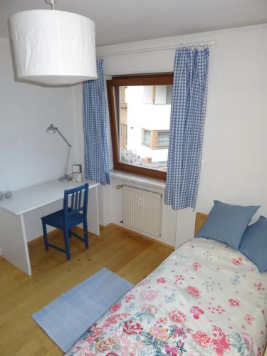 um quarto com uma cama, uma secretária e uma janela em Appartamento Norma em Val di Vizze