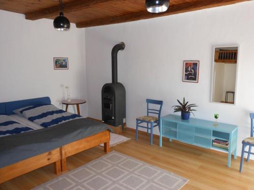 a bedroom with a bed and a wood stove at Merum Pincészet és Vendégszoba in Tállya