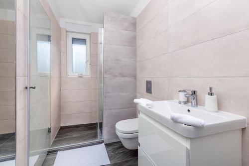łazienka z toaletą, umywalką i prysznicem w obiekcie Apartment LAGANINI III w mieście Nijvice