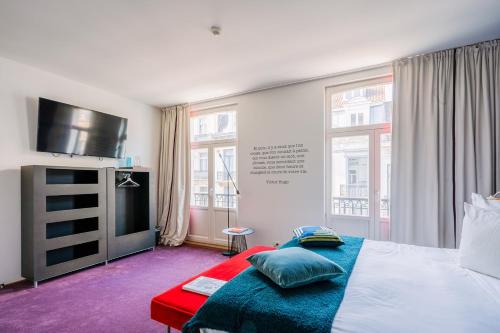 a bedroom with a bed and a flat screen tv at Smartflats - Pacific Brussels in Brussels