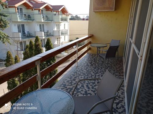 a balcony with chairs and tables on a building at Tavaszház Apartmanok in Balatonfüred