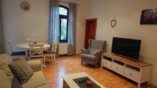a living room with a flat screen tv and a table at Ferienwohnung im Grünen - Hof Blohme in Langwedel