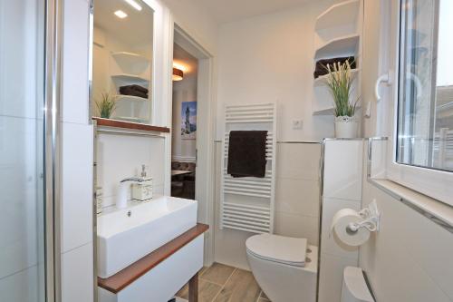 a white bathroom with a sink and a toilet at Bungalow-Park Ostseenordstern in Wustrow