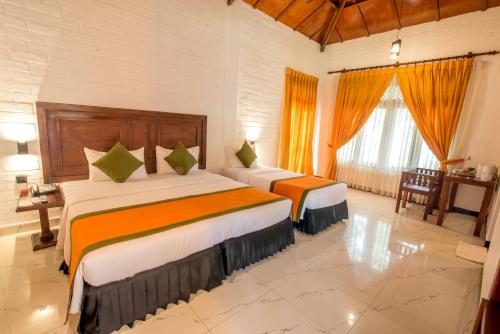 Postel nebo postele na pokoji v ubytování Mahanuge Hotel Polonnaruwa