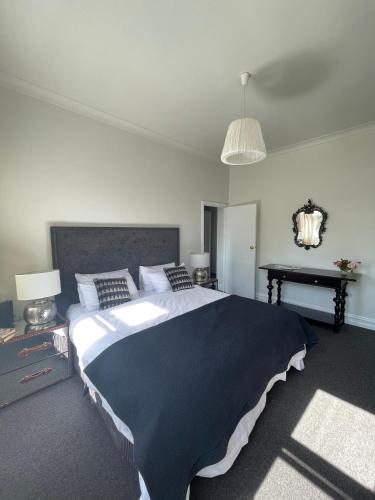 a bedroom with a large bed and a piano at Webster Terrace in Ballarat