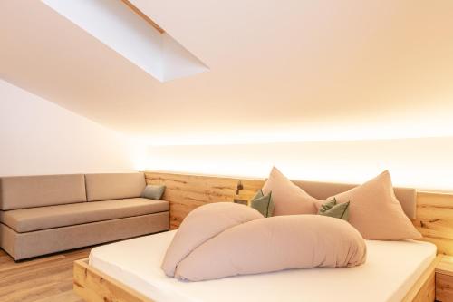 a living room with a couch and a bed at Residence Alpina in Santa Maddalena in Casies