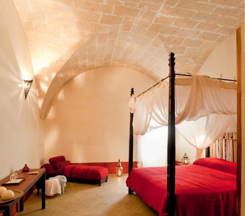 a bedroom with a bed with a red bedspread at La Casa Dell'Arancio in Favignana