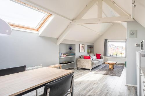 a kitchen and living room with a vaulted ceiling at Studio Wolken, Wind en Water. in Petten