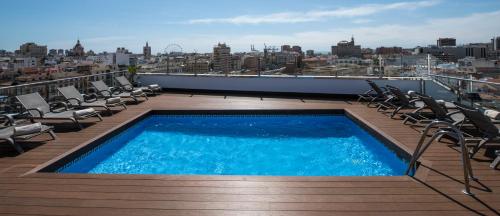 a swimming pool on the roof of a building at Salles Hotel Málaga Centro in Málaga