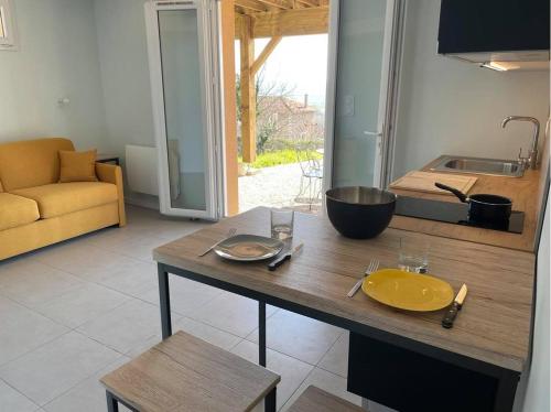 una cocina con una mesa con un tazón amarillo. en Studio indépendant au calme avec vue imprenable en Bossieu