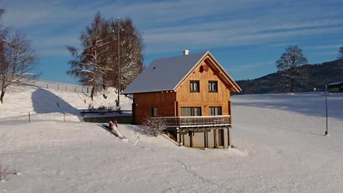 a small wooden house in the snow with snow at Ferienhaus Lärchenhütte in Kasperle