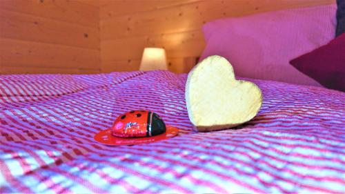 a heart and a ladybug toy on a bed at Ferienhaus Lärchenhütte in Kasperle