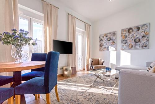 uma sala de estar com uma mesa e cadeiras azuis em Genteel Home Recaredo em Sevilha