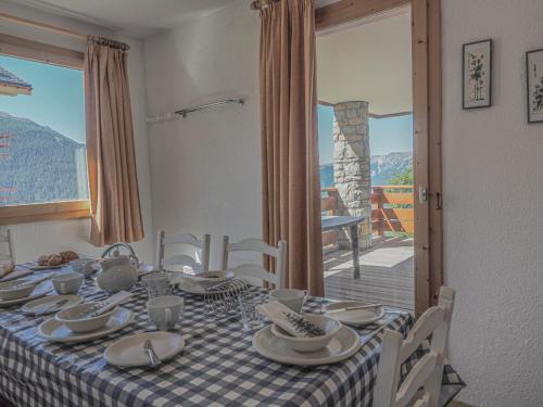 une table de salle à manger avec une nappe à carreaux dans l'établissement Les Epilobes 3, à Landry