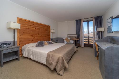 a bedroom with a bed and a couch and a television at Principi di Piemonte Sestriere in Sestriere