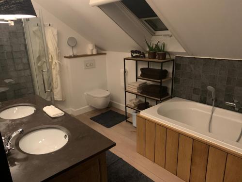 a bathroom with two sinks and a bath tub at Maas Lodge in Maaseik