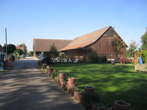 a barn and a road in front of a yard at Schlaffass-Camping Gutshof Donauried in Günzburg