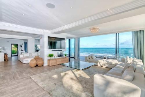 a living room with white furniture and a view of the ocean at Marlin Manor in Struisbaai