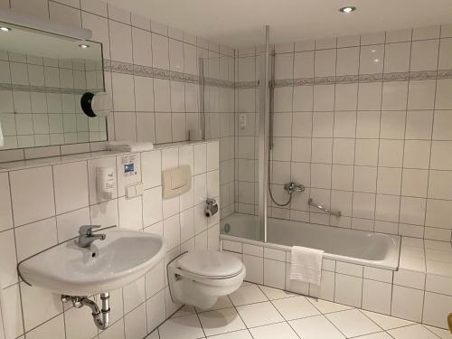 uma casa de banho com um lavatório, um WC e uma banheira em Hotel Europa em Ramstein-Miesenbach