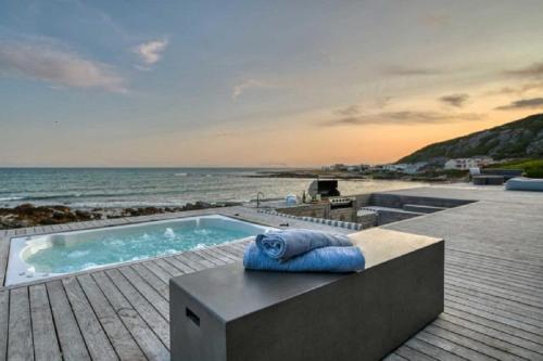 a swimming pool sitting on a deck next to the beach at Marlin Manor in Struisbaai