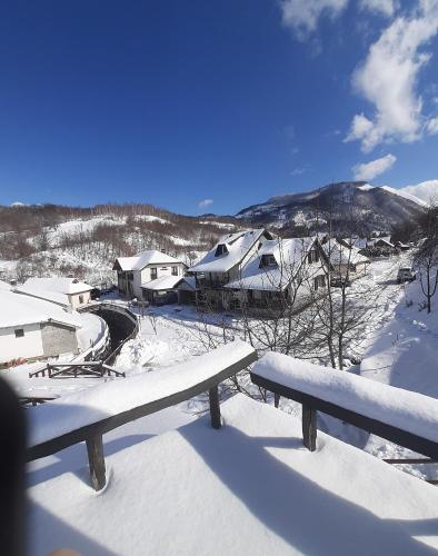 a bench sitting on top of a snow covered yard at Rooms and apartmants Mirovic in Kolašin