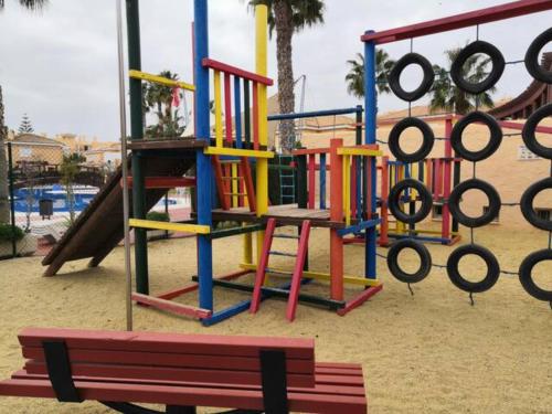 un parque infantil con equipo de juegos y un banco en El apartamento que buscas Vera Playa, en Los Amarguillos