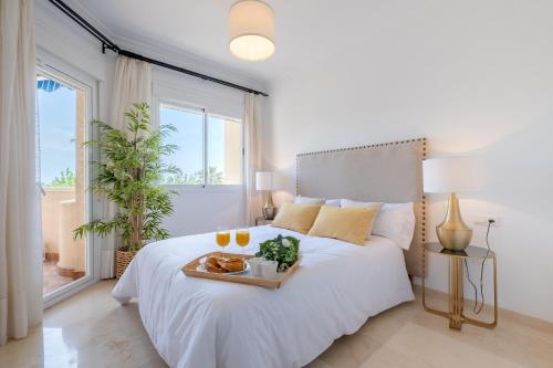Un dormitorio con una cama con una bandeja de comida. en Garden & Beach - Torremolinos en Torremolinos