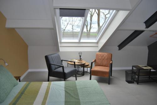 um quarto com uma cama, uma mesa e cadeiras em Hoeve de Heemser Parel em Heemserveen