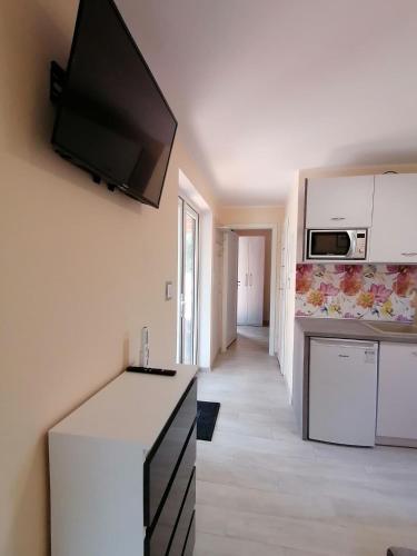a kitchen with a flat screen tv on the wall at ApartDomek CICHE in Zbiczno