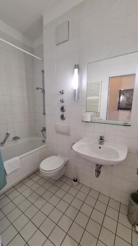 ein weißes Bad mit einem Waschbecken und einem WC in der Unterkunft TopDomizil Apartments Berlin Mitte in Berlin