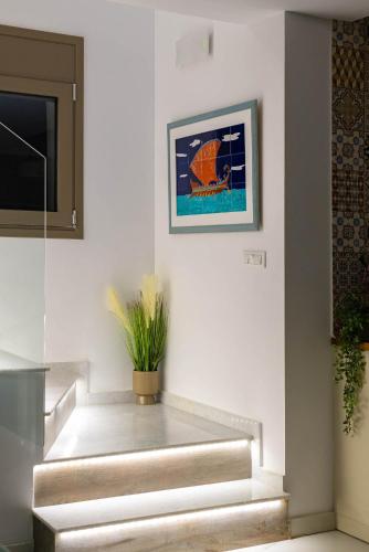 a stairway with a painting and a plant on the wall at Ikaros Villa in Pefki Rhodes