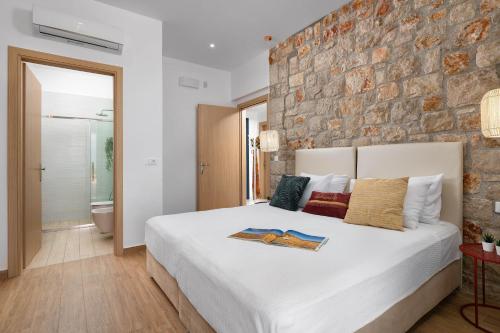 a bedroom with a large bed and a stone wall at Ikaros Villa in Pefki Rhodes