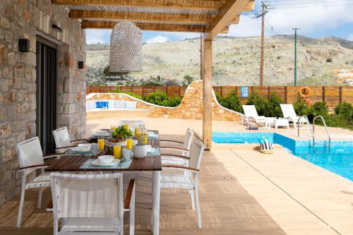 a patio with a table and chairs and a pool at Ikaros Villa in Pefki Rhodes