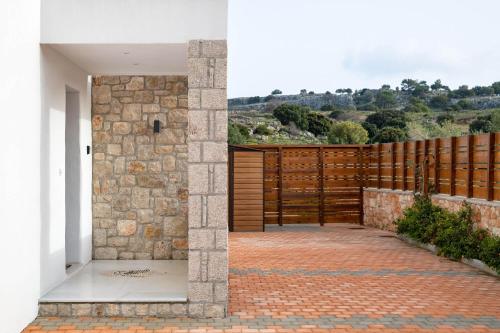 a pivot door in a house with a stone wall at Ikaros Villa in Pefki Rhodes