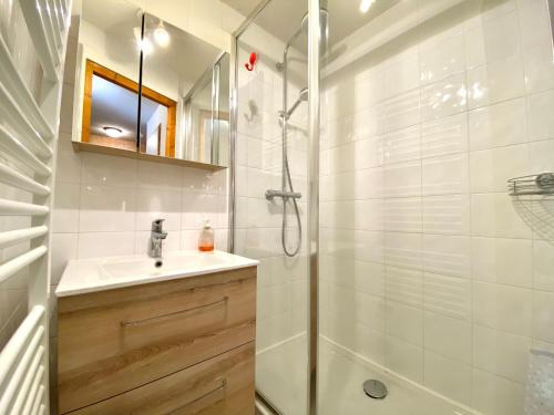 une salle de bain avec une douche, un lavabo et un miroir dans l'établissement RANFOLLY 8, à Morzine