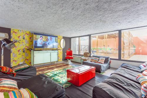 ein Wohnzimmer mit einem Sofa und einem TV in der Unterkunft Résidence Kley in Marseille