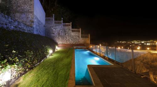 a swimming pool in front of a building at night at Casa Marcial (adults only) in Besalú