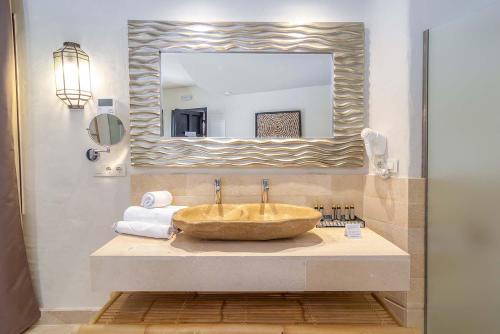 ein Badezimmer mit einem großen Waschbecken und einem Spiegel in der Unterkunft El Cortijo de Zahara by QHotels in Zahara de los Atunes