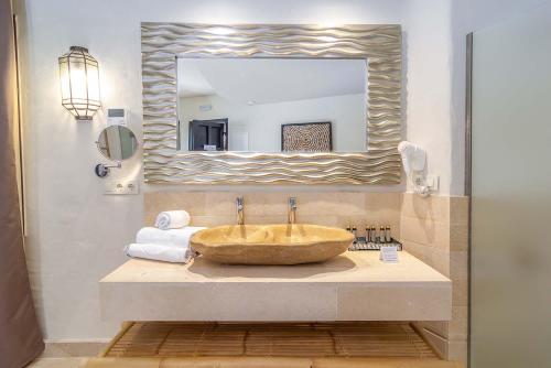 a bathroom with a large sink and a mirror at El Cortijo de Zahara by QHotels in Zahara de los Atunes