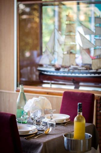 een tafel met borden en flessen wijn en een raam bij Hôtel Christina Lourdes in Lourdes