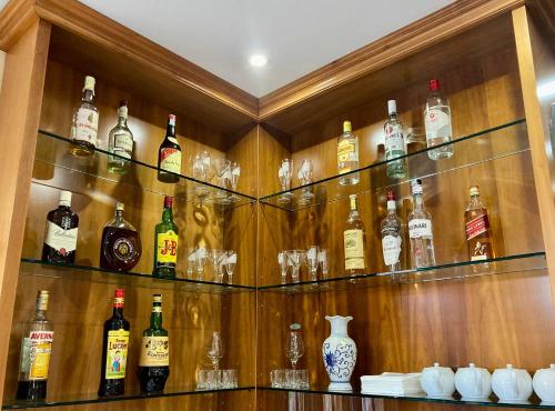 a cabinet filled with lots of bottles of alcohol at Hotel Visconti in Melzo