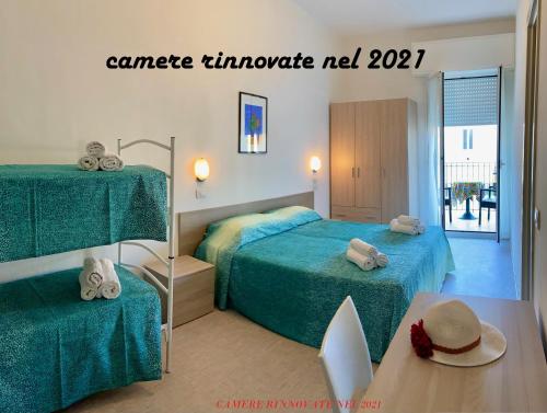 a room with two beds and a table with a mirror at Petite Maison Lido in Cattolica