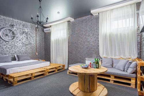 クラスノダールにあるMarton Boutique and Spa Krasnodarのベッドルーム1室(ベッド1台、ソファ、テーブル付)